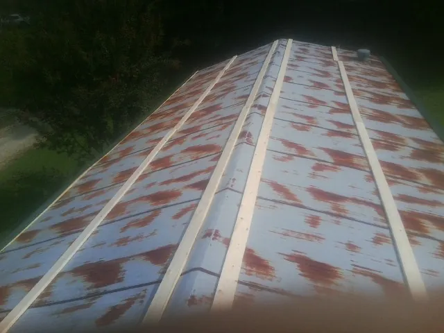 Rusted metal roof panels with new wood purlins before replacement — Storm Damage Roof Repair in Pearlington by Roofing Brothers