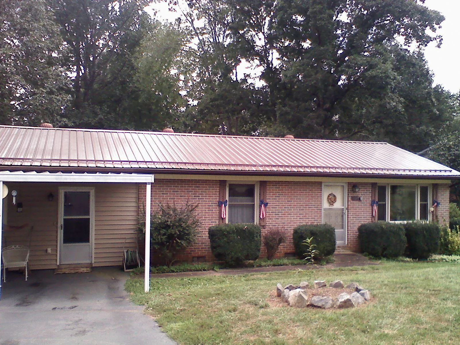 Bronze metal roof and carport on a brick ranch home — Roof Repair work by our crew in Pearlington